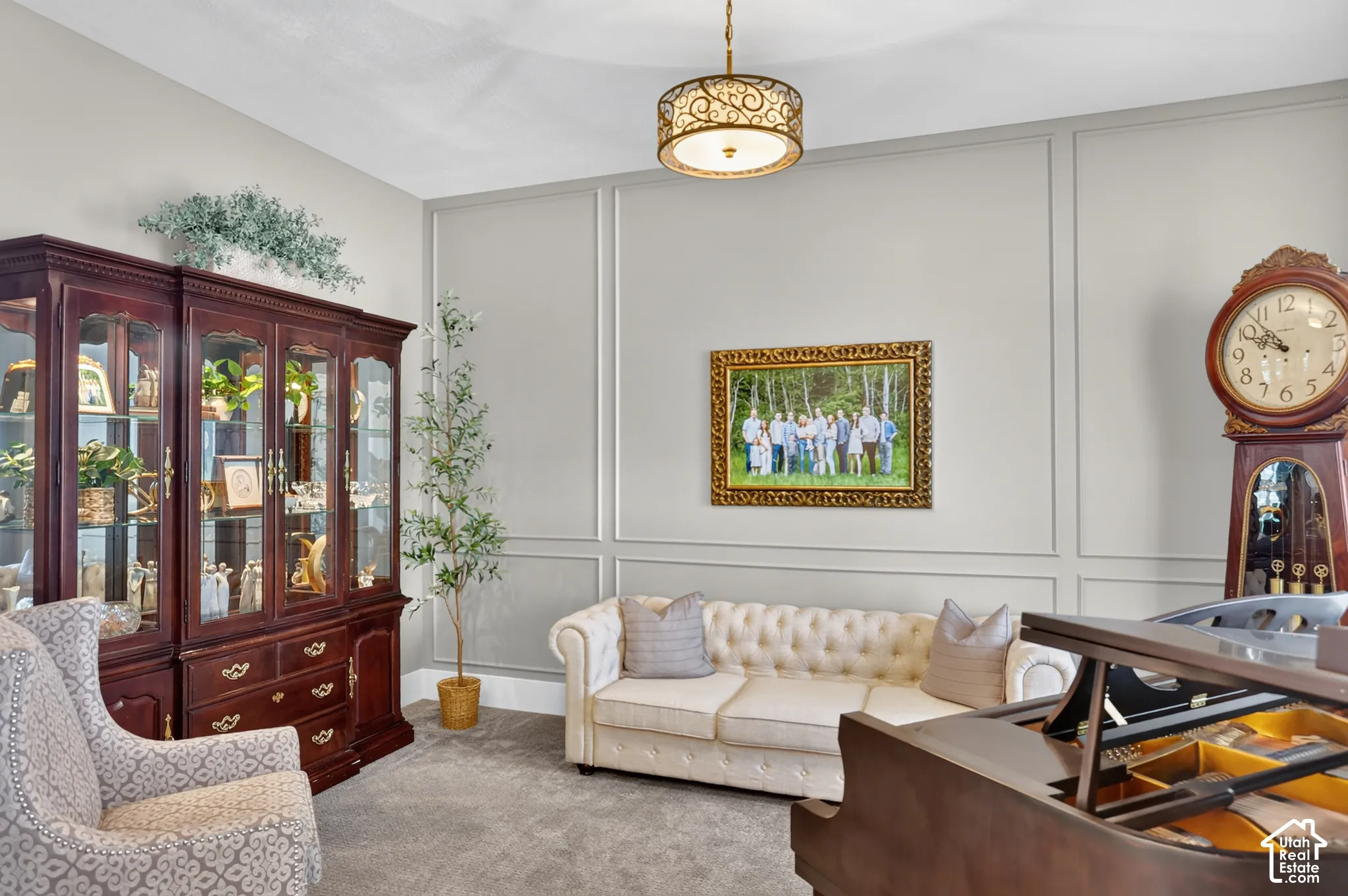 Wall molding detailing, neutral wall finish, and a decorative drum-style chandelier with filigree metalwork