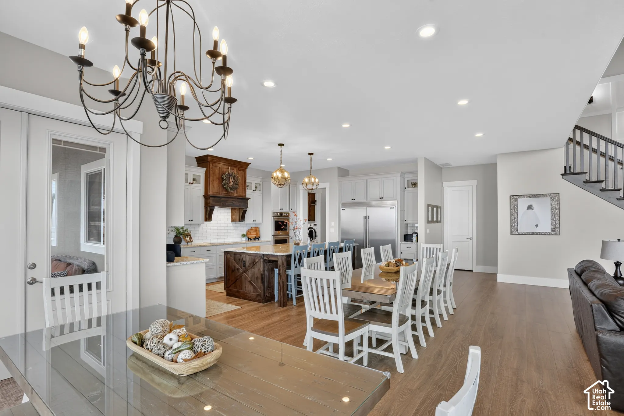 Open-concept kitchen featuring a stained wood island with X-brace detailing, recessed lighting, white cabinetry, a tiled backsplash, and wood-finish flooring