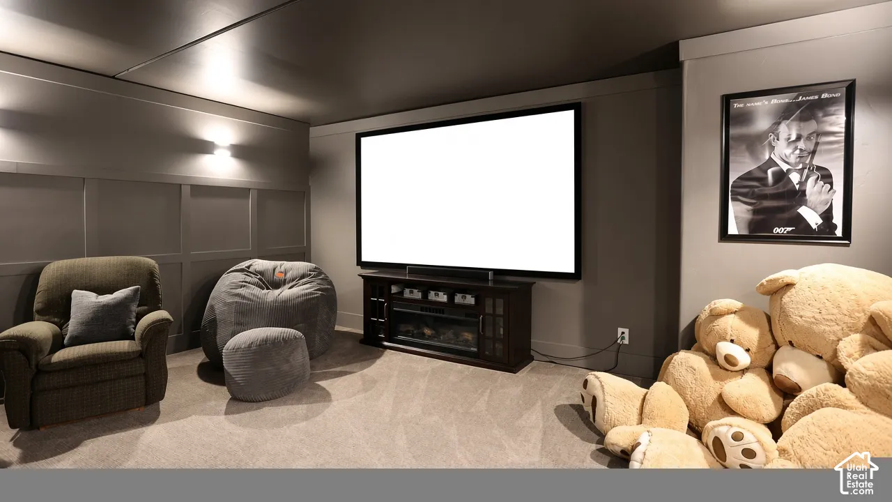 Media room featuring wall-to-wall carpeting, wood-paneled walls, and wall-mounted lighting