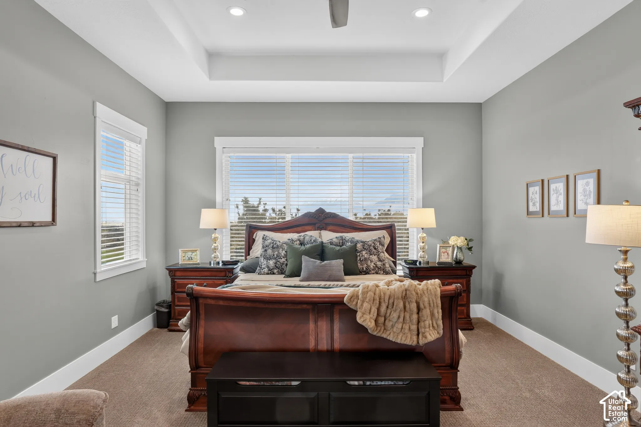 Tray ceiling with recessed lighting and neutral-toned walls, featuring large windows with window blinds and carpeting