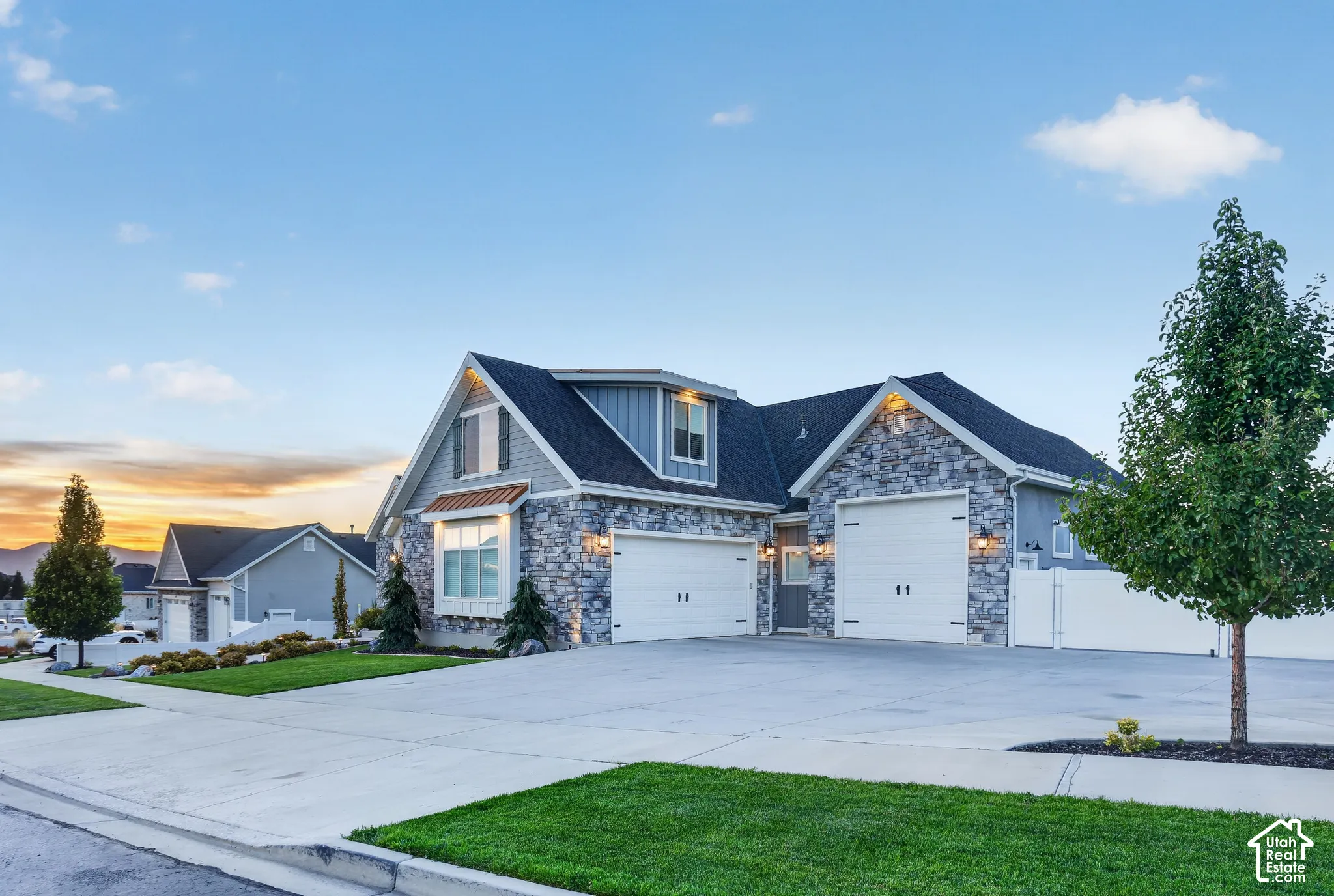 Exterior featuring stone masonry cladding, horizontal siding, multiple gabled rooflines, and a three-car garage