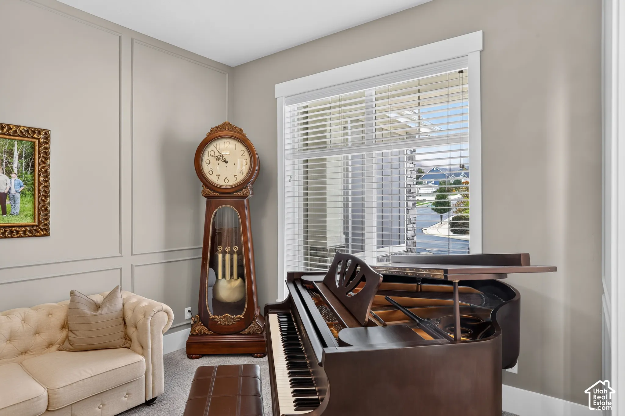 Interior room featuring picture frame wall molding, neutral-toned walls, and a large window with horizontal blinds
