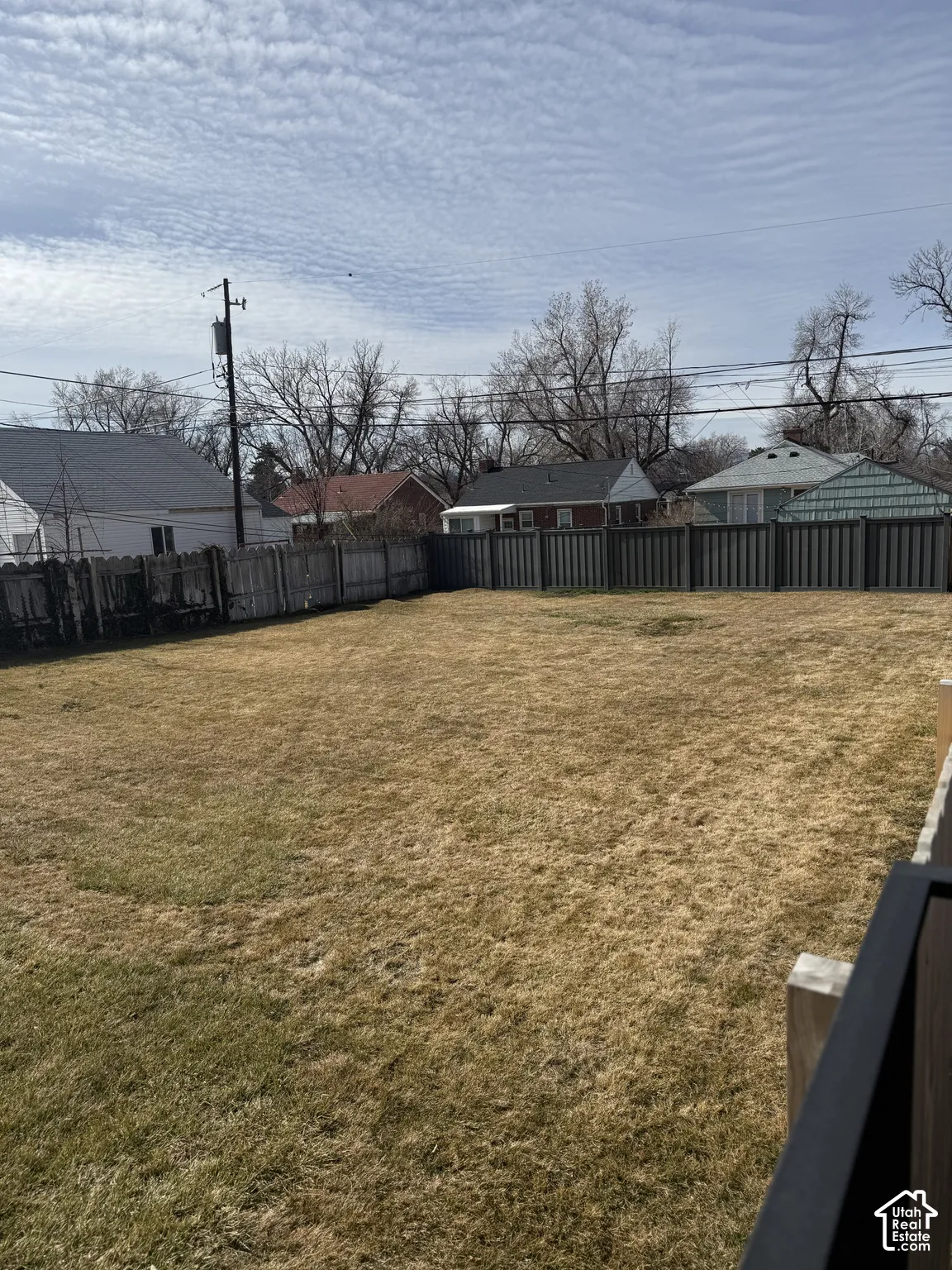 Expansive backyard featuring an open lawn and full-perimeter privacy fencing