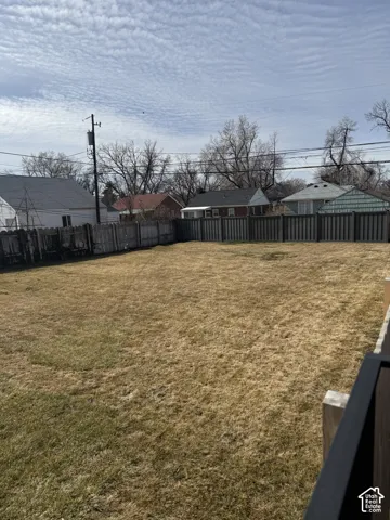 Expansive backyard featuring an open lawn and full-perimeter privacy fencing
