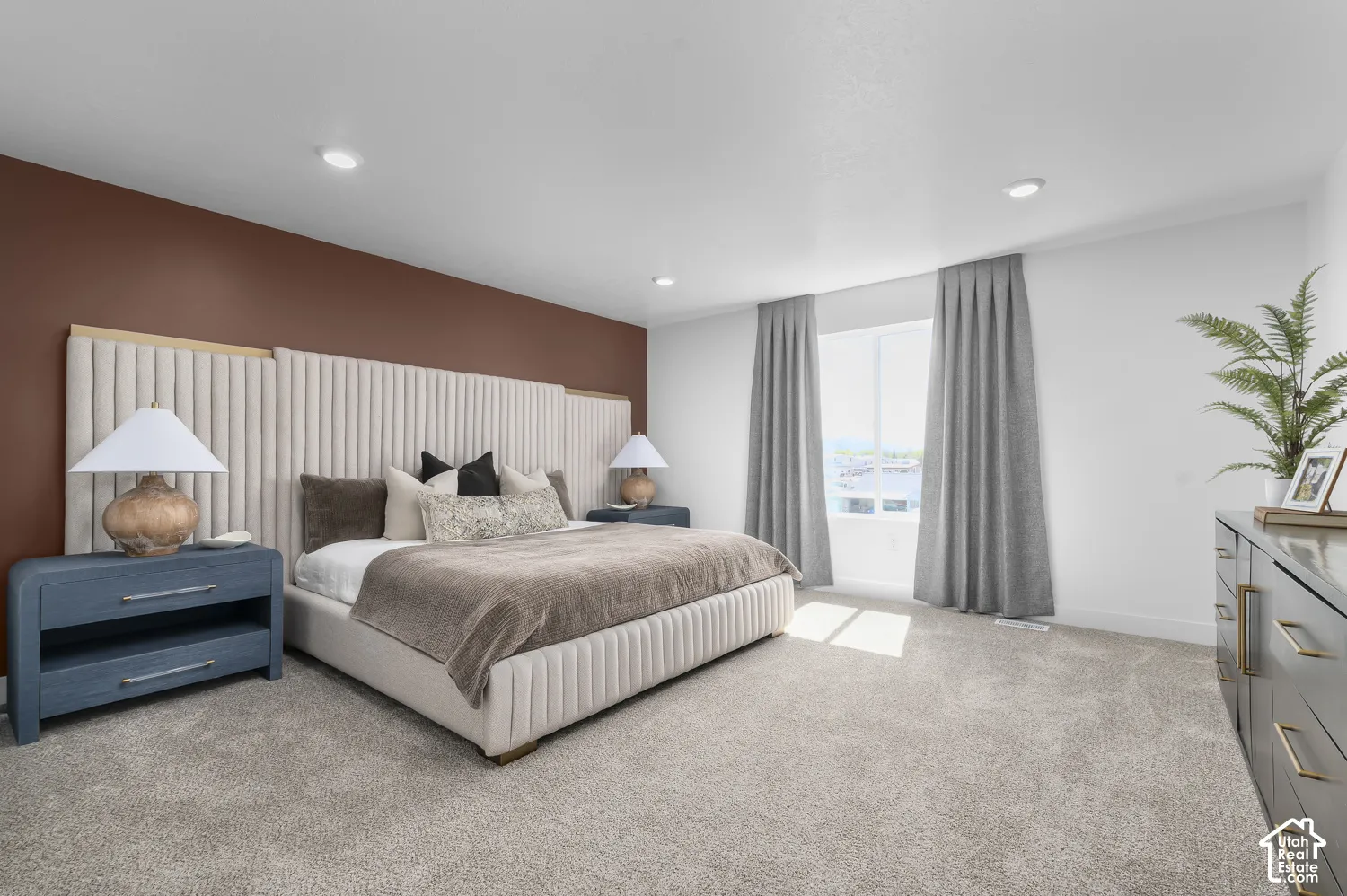 Bedroom featuring a custom vertical channel-tufted upholstered headboard, a dark brown accent wall, neutral carpeting, and recessed lighting