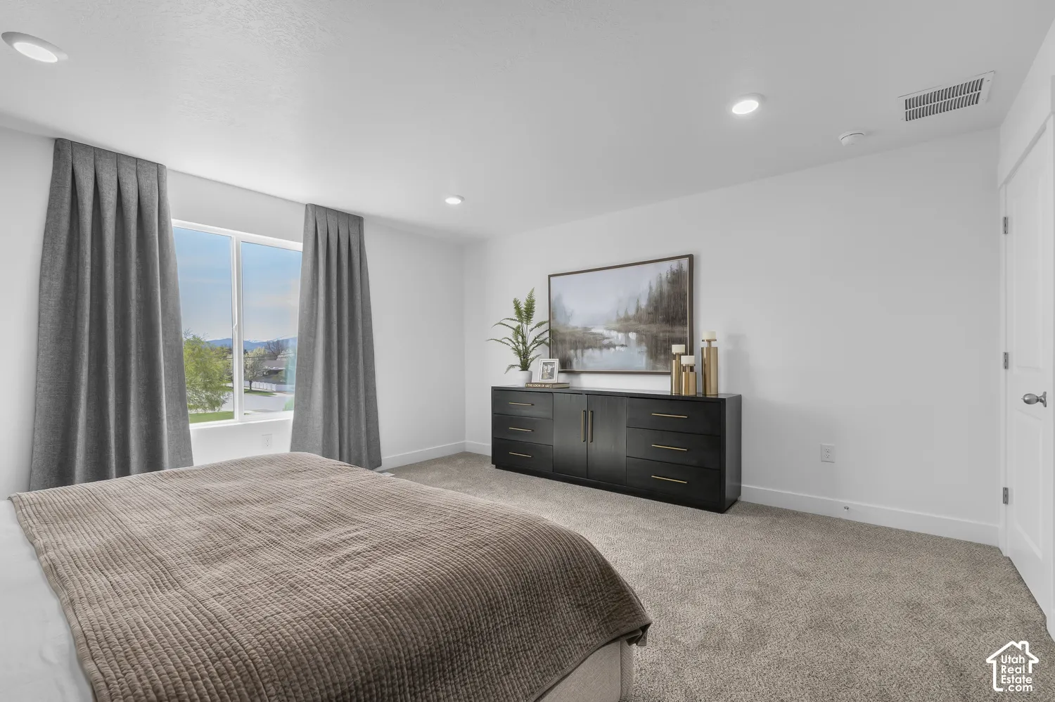 Neutral interior featuring light-toned walls, recessed lighting, carpeted flooring, and a window with exterior mountain scenery