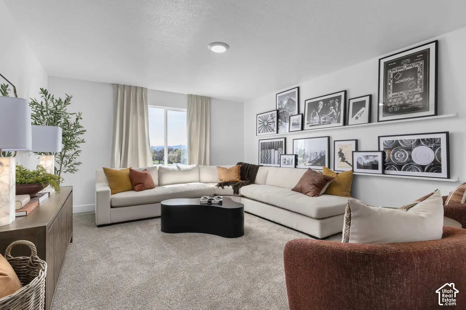 Living area featuring neutral carpeting, wall-mounted display shelving, a single window, and a recessed ceiling light