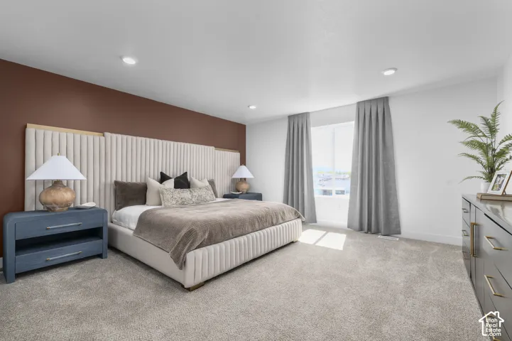 Bedroom featuring a custom vertical channel-tufted upholstered headboard, a dark brown accent wall, neutral carpeting, and recessed lighting