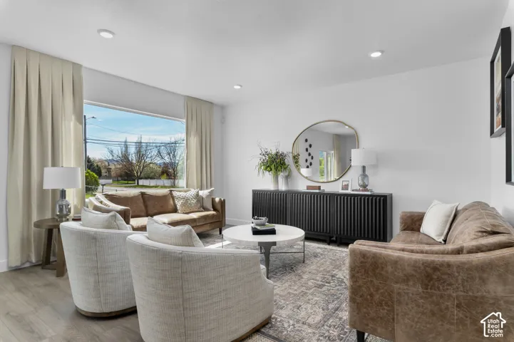 Living area featuring wood-finish flooring, recessed lighting, and a large picture window