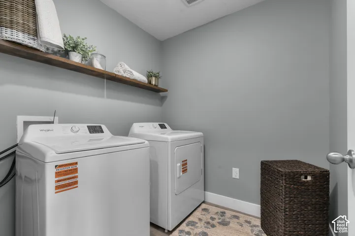 Laundry space featuring a wall-mounted wood-finish shelf and neutral wall paint