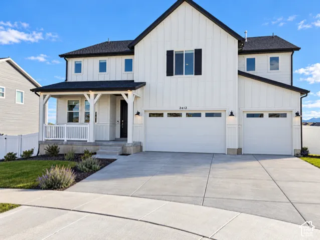 Modern farmhouse exterior featuring vertical board-and-batten siding, a covered front porch with white railing, a three-car garage, and asphalt shingle roofing