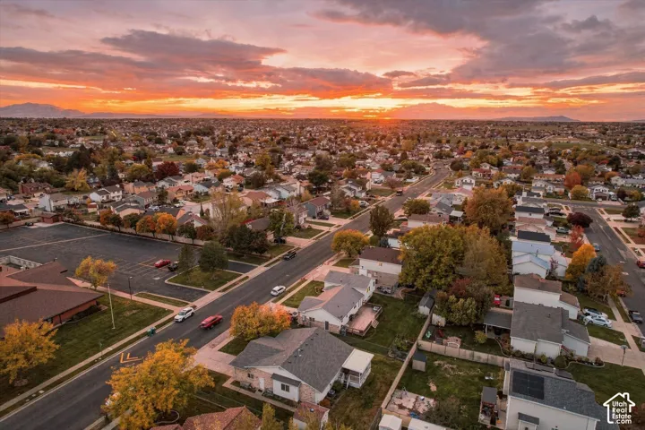 Aerial perspective featuring mountain silhouettes, an expansive horizon, and mature deciduous landscaping