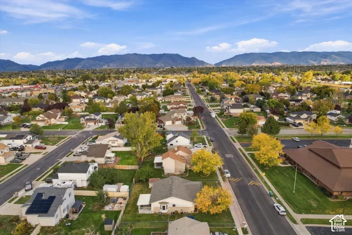 Aerial perspective featuring established neighborhood surroundings, mature trees, and a mountain range backdrop