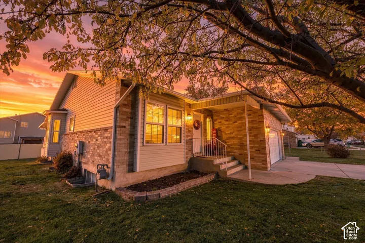 Single-story residence featuring a mixed brick and vinyl siding exterior, a concrete driveway, a covered front entryway with metal railing, and a bay window