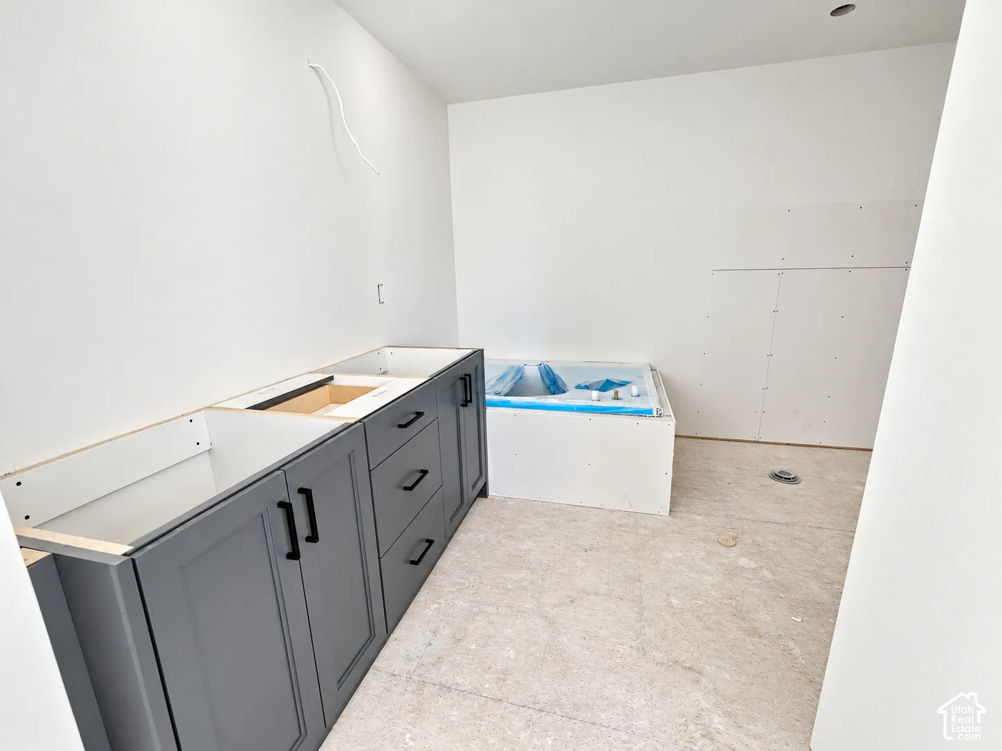 Shaker-style charcoal cabinetry with matte black hardware and a built-in soaking tub surround