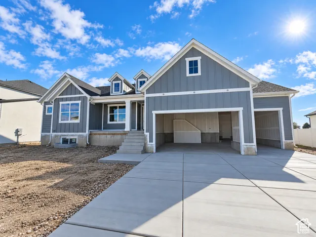 Vertical board-and-batten siding, multi-gabled roofline, three-car garage, and concrete driveway