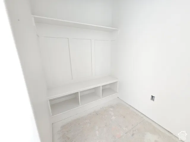 Built-in storage bench featuring three lower cubbies, custom wall molding, and an upper shelf