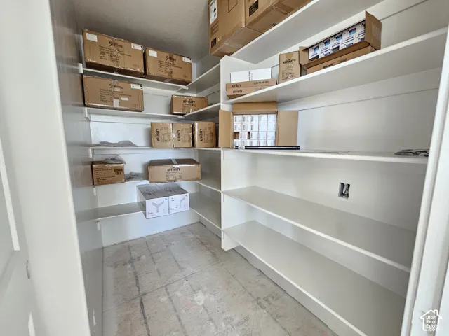 Walk-in storage space featuring multi-level white built-in shelving
