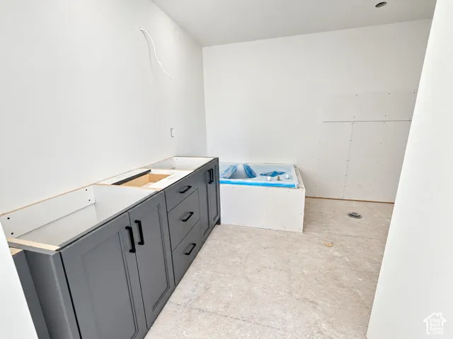 Shaker-style charcoal cabinetry with matte black hardware and a built-in soaking tub surround