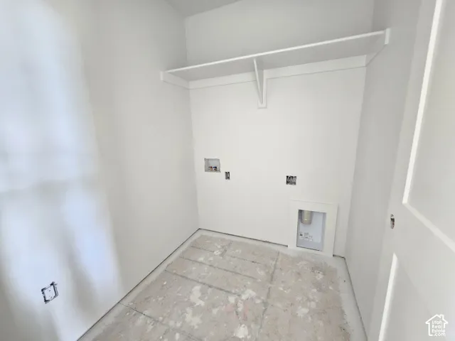 Utility room featuring a built-in overhead shelf, dedicated plumbing connections for laundry appliances, and an integrated wall-mounted exhaust vent