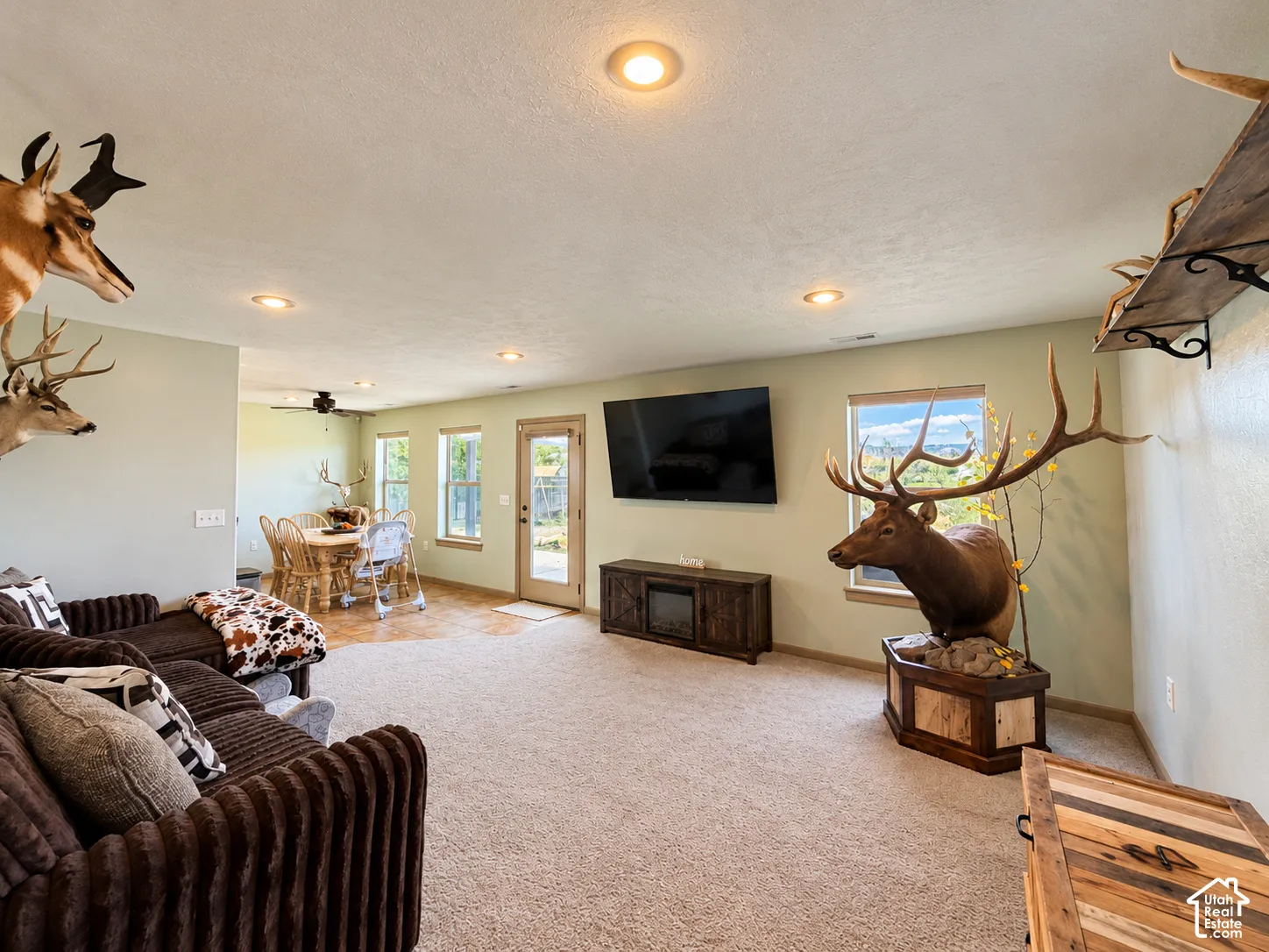 Open-concept interior featuring recessed lighting, neutral wall paint, carpeting, and multiple windows