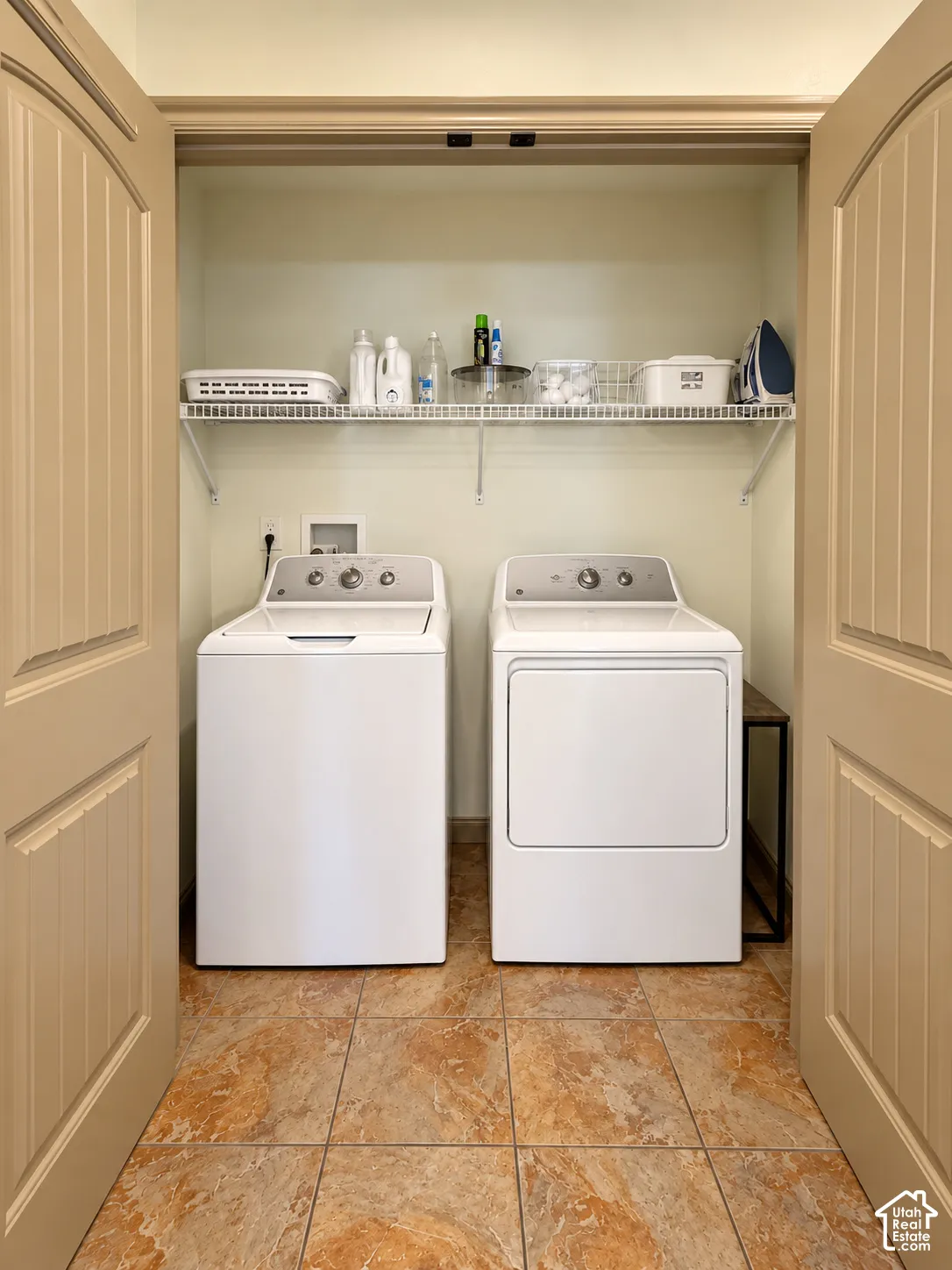 Utility closet featuring ceramic tile flooring, dual-panel interior doors, and integrated wire shelving