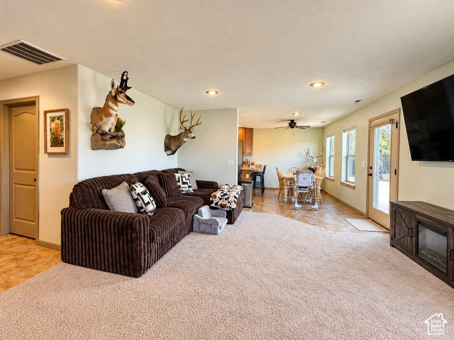 Open-concept interior featuring recessed lighting, tile flooring, wall-to-wall carpeting, and a glass-paneled exterior door