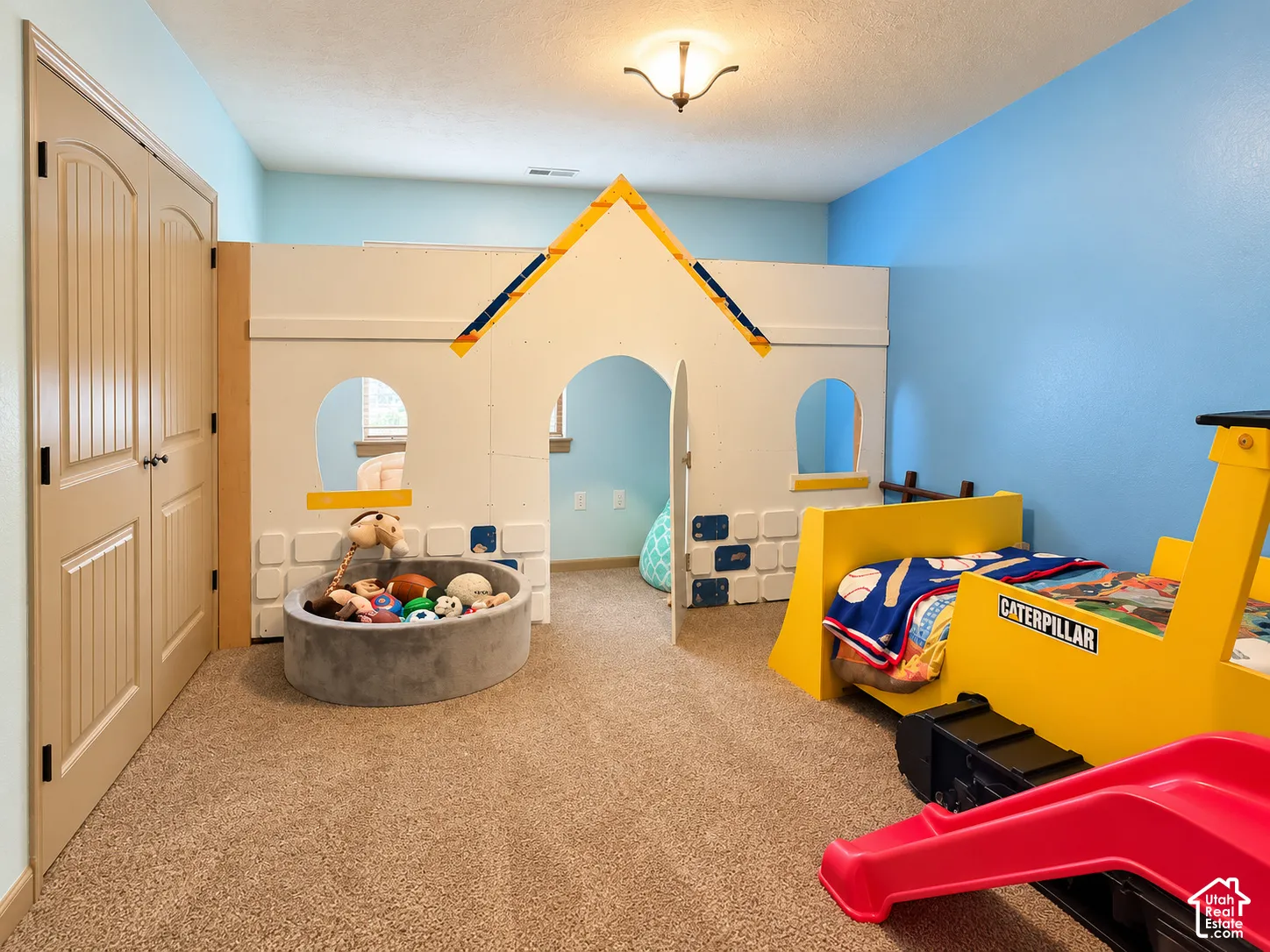 Room featuring neutral-toned carpeting, dual-paneled interior doors, and a built-in custom structural play partition