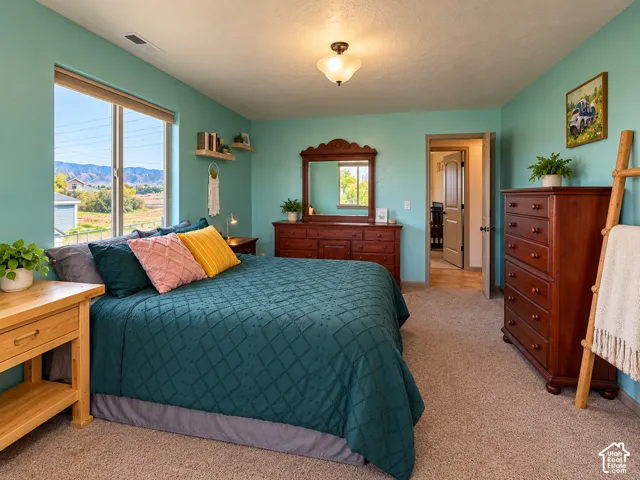 Spacious room featuring neutral carpeting, a large picture window, and a semi-flush mount ceiling fixture