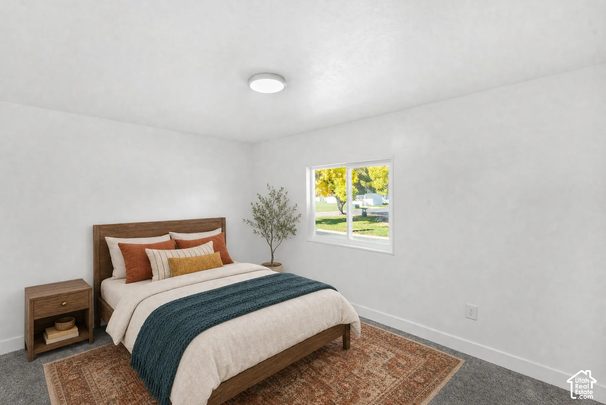 Neutral-toned room featuring plush carpeting, smooth white walls, and a recessed ceiling light fixture