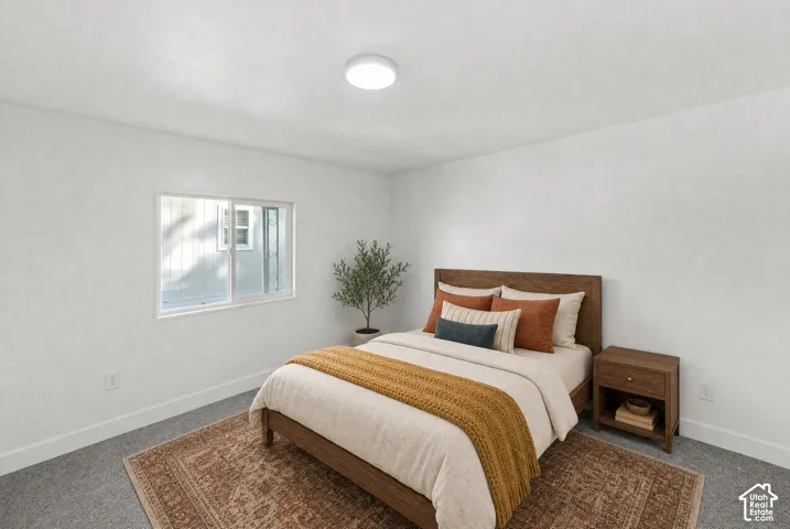 Neutral-toned room featuring wall-to-wall carpeting, a sliding window, and a circular flush-mount ceiling light fixture