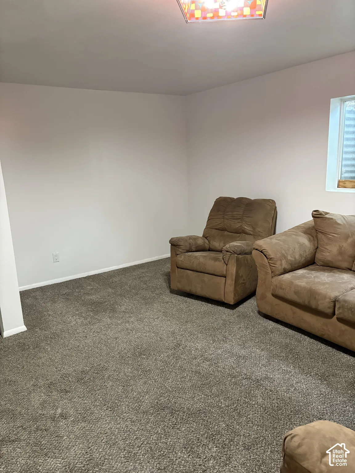 Neutral-toned interior space featuring wall-to-wall carpeting and a recessed window