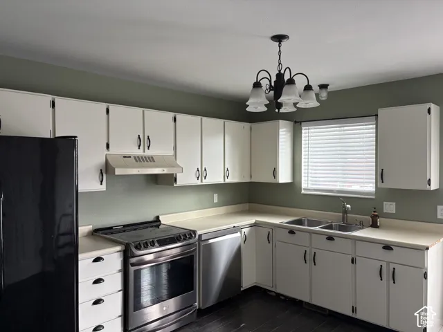 Kitchen featuring white cabinetry, stainless steel appliances, a double-basin sink, and dark-toned wood-finish flooring