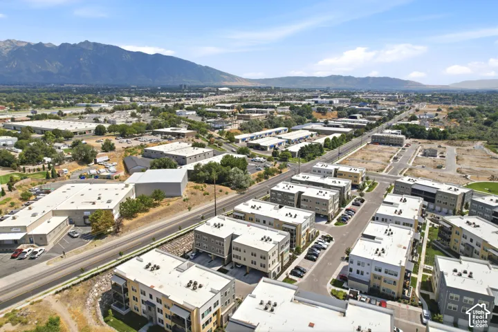 Aerial perspective featuring multi-story residential structures, paved access roads, and prominent mountain backdrops