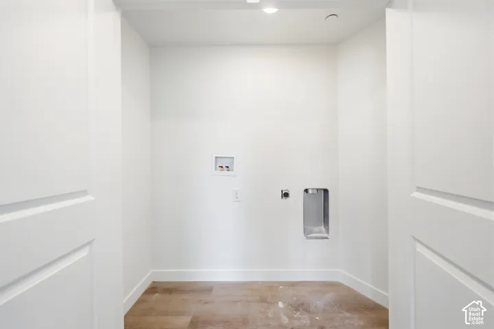 Laundry alcove featuring double-panel doors, recessed ceiling lighting, and wood-finish flooring