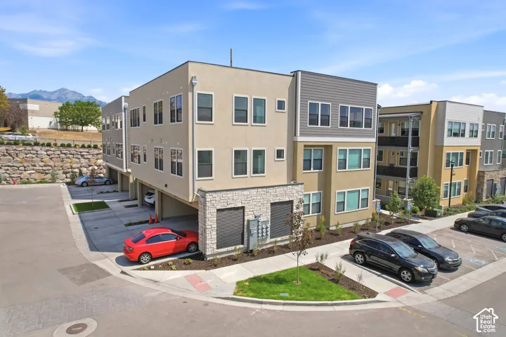 Multi-level exterior featuring stucco and horizontal siding, stone veneer accents, covered parking, and mountain scenery