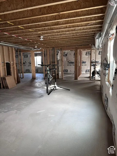 Unfinished lower level featuring exposed wood joist ceilings, concrete flooring, and perimeter wood-frame stud walls