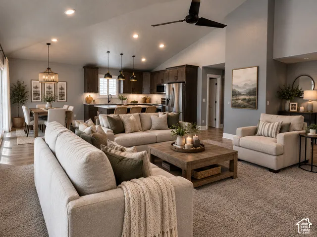 Vaulted ceilings featuring recessed lighting and a matte black ceiling fan, dark-toned cabinetry, stainless steel appliances, and a kitchen island with pendant lighting