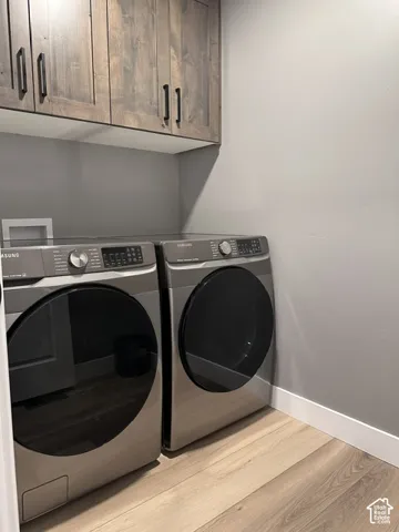 Stained wood cabinetry with matte black hardware, wood-finish flooring, and neutral wall paint