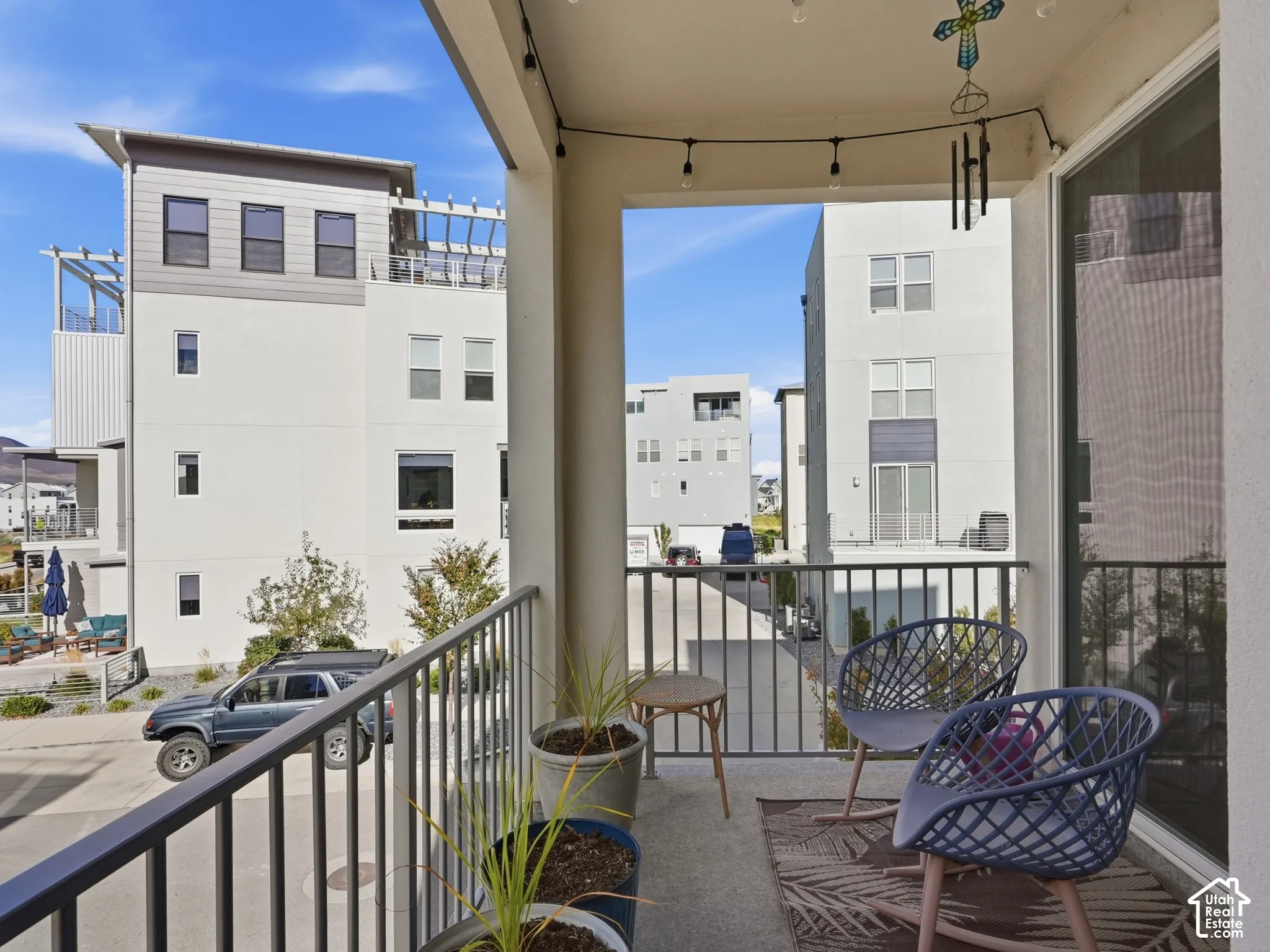 Covered balcony featuring concrete flooring, a metal railing, and sliding glass entry door