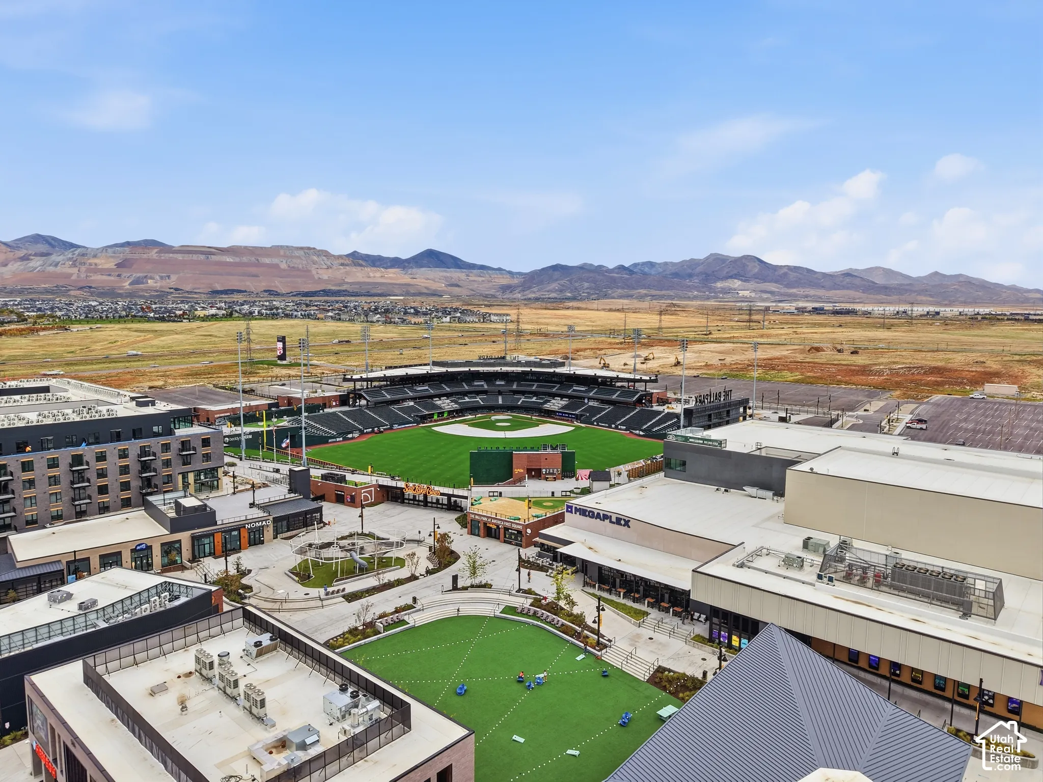 Aerial perspective featuring proximity to a professional baseball stadium, retail complex, and mountain scenery