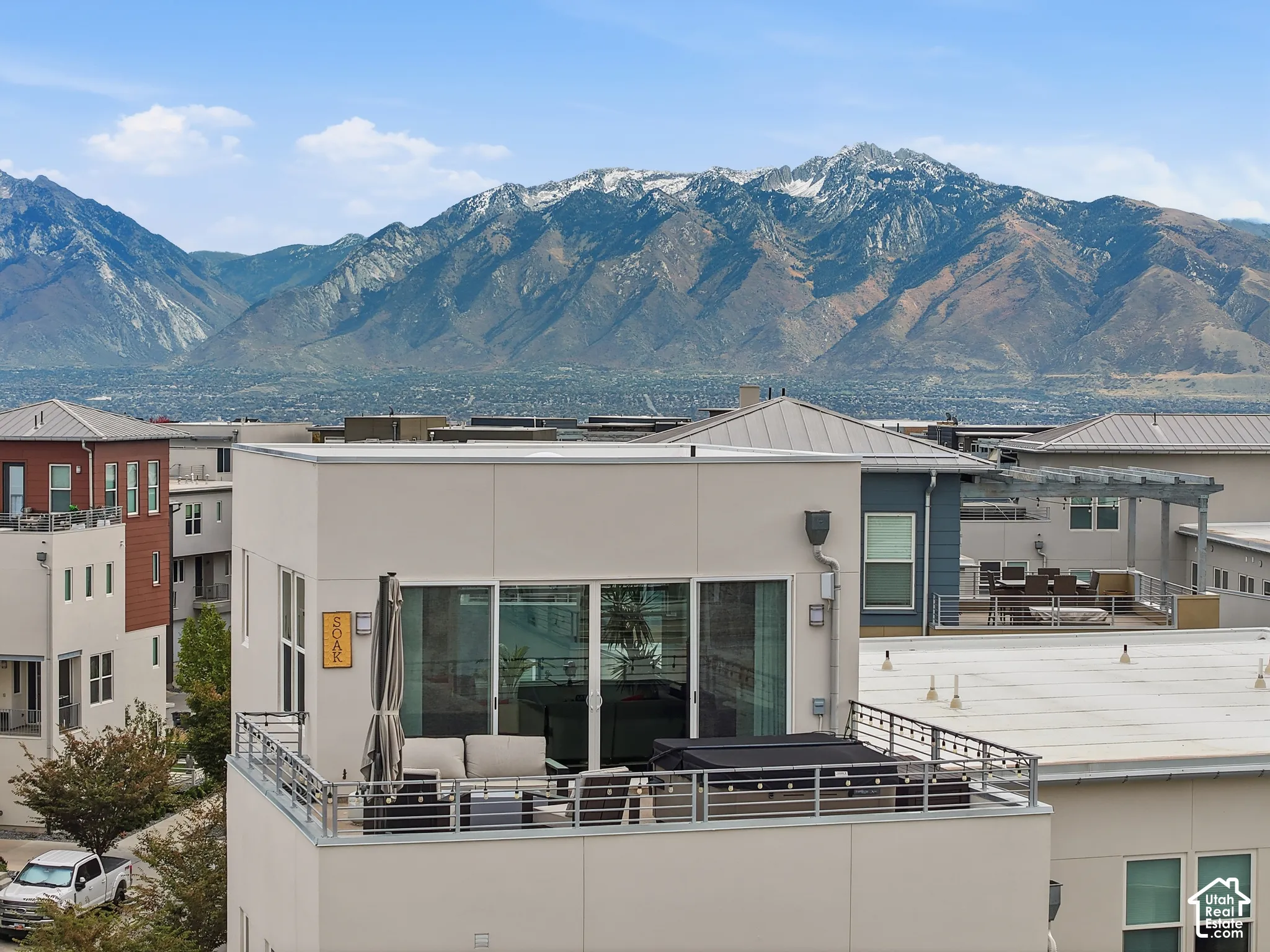 Rooftop terrace featuring metal railing and expansive mountain backdrop