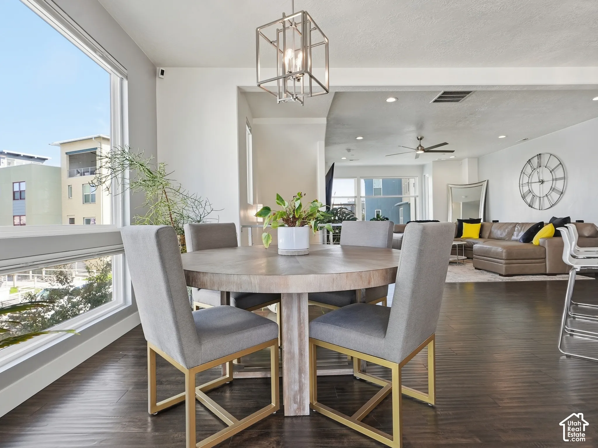 Open concept area featuring dark wood-finish flooring, recessed lighting, geometric metal pendant light, and floor-to-ceiling windows