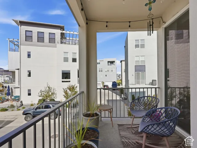 Covered balcony featuring concrete flooring, a metal railing, and sliding glass entry door