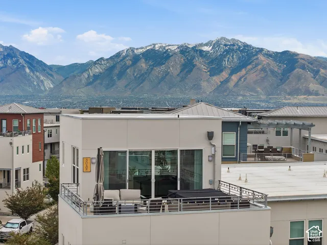 Rooftop terrace featuring metal railing and expansive mountain backdrop