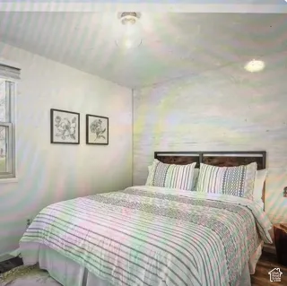 Textured accent wall, neutral wall finish, flush-mount lighting, and multi-pane window
