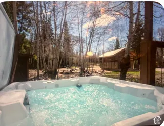 Built-in spa with integrated seating, exterior log structure, and mature tree canopy