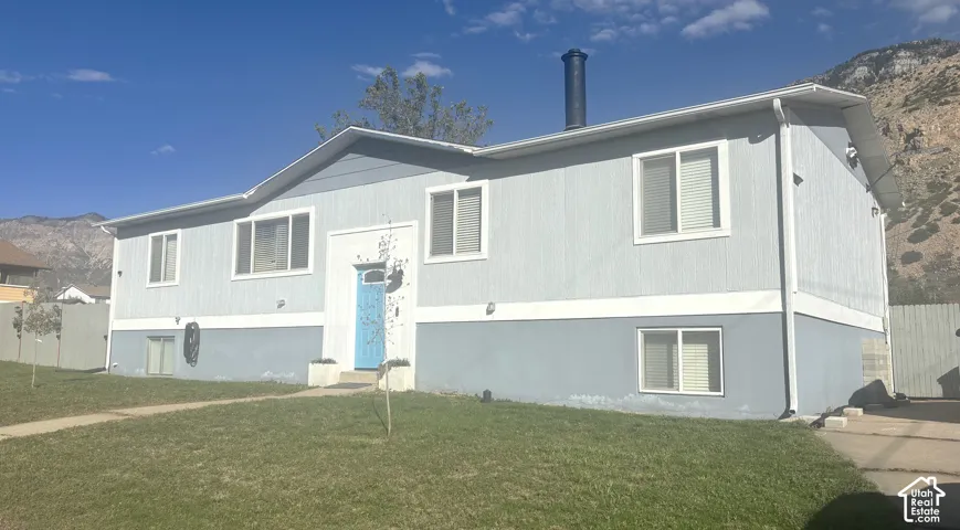 Single-story exterior featuring two-tone siding, a central entryway, sliding windows, and a mountain backdrop