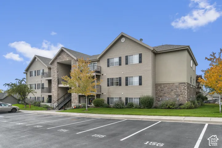 Multi-story exterior featuring horizontal siding, natural stone veneer accents, multi-gabled rooflines, shuttered windows, and private balconies