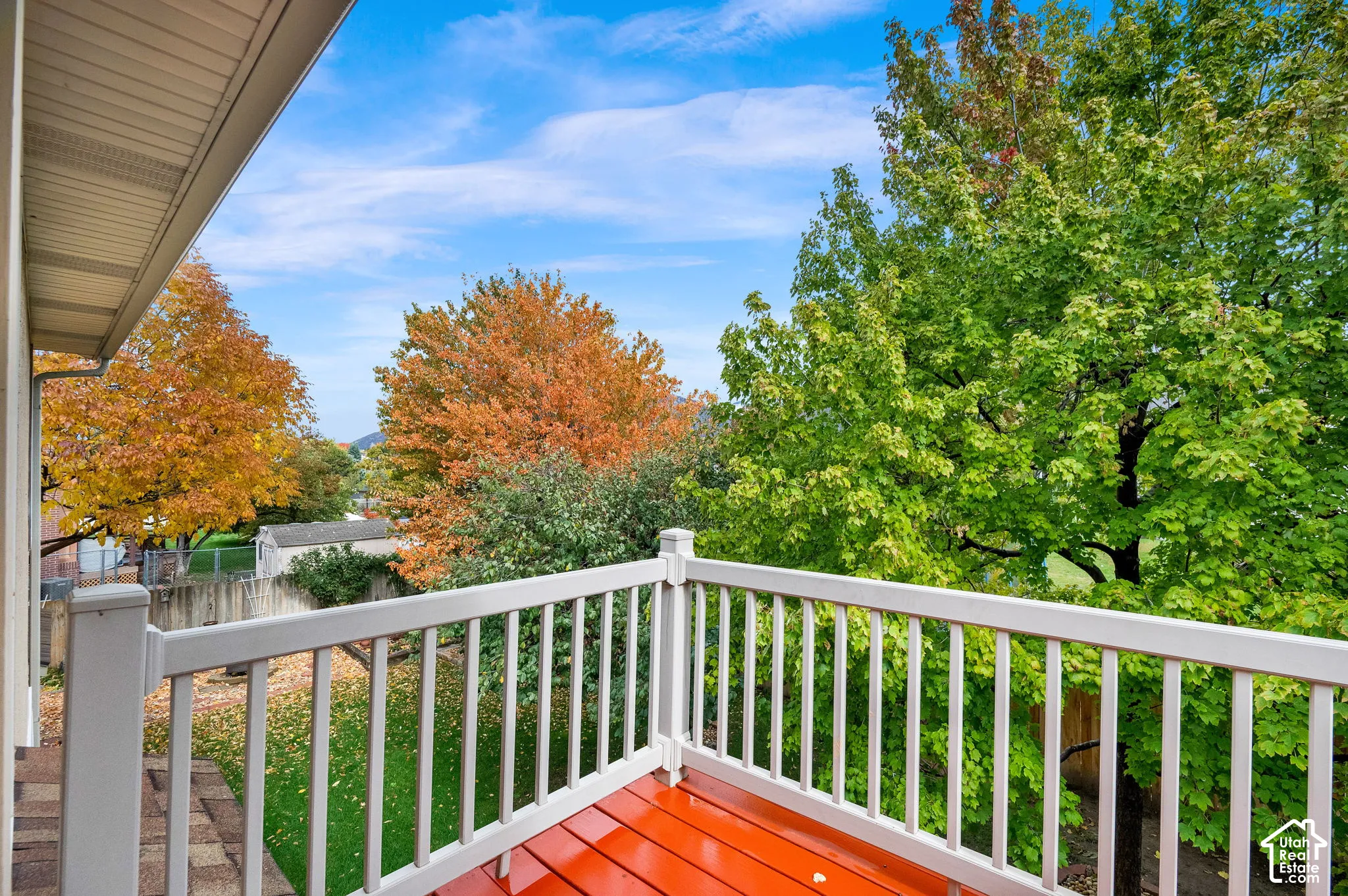 Elevated deck featuring white composite railings and finished wood-tone flooring